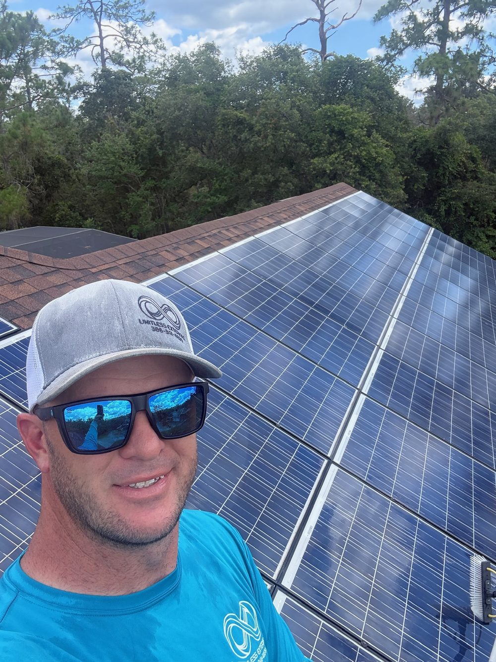 Matt Cavanaugh, owner of Limitless Exteriors, on a roof beside a freshly cleaned solar array